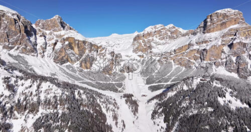 Aerial drone view of the mountains in the Colfosco village covered in snow, in South Tyrol, Dolomites, Northern Italy - Starpik Stock