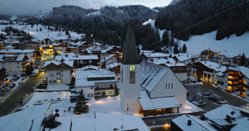 Corvara in Badia, Italy – January 9, 2025: Aerial drone view of the Corvara village covered in snow at blue hour, in South Tyrol, Dolomites, in northern Italy - Starpik Stock