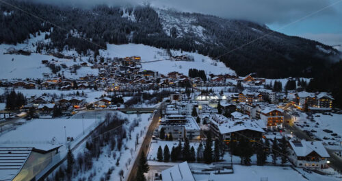 Corvara in Badia, Italy – January 9, 2025: Aerial drone view of the Corvara village covered in snow at blue hour, in South Tyrol, Dolomites, in northern Italy - Starpik Stock
