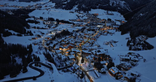 Corvara in Badia, Italy – January 9, 2025: Aerial drone view of the Corvara village covered in snow at night, in South Tyrol, Dolomites, in northern Italy - Starpik Stock