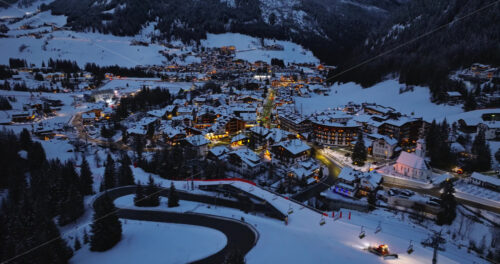 Corvara in Badia, Italy – January 9, 2025: Aerial drone view of the Corvara village covered in snow at night, in South Tyrol, Dolomites, in northern Italy - Starpik Stock