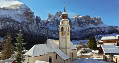 Video – Colfosco, January 9, 2025: Aerial drone view of the Parrocchia di Colfosco in the Colfosco mountain village covered in snow, in South Tyrol, Dolomites, Northern Italy - Starpik Stock