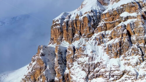 video Aerial drone view of snow on the Sassongher mountain in the Dolomites, Italy with the blue sky on the background - Starpik Stock