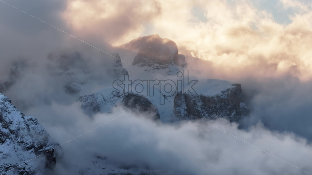 video Aerial drone view of the snowy mountains in the clouds, in the Dolomites, Italy - Starpik Stock