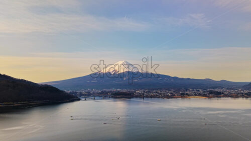 Aerial drone view of boats moving on Lake Kawaguchiko near the Fujikawaguchiko town, Japan with Mount Fuji on the background - Starpik Stock
