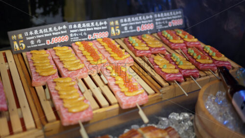 Close up of Wagyu beef with different toppings on skewers at the Tsukiji Fish Market in Chuo, Tokyo, Japan - Starpik Stock