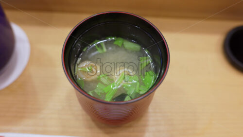Close up of a cup of Miso soup and nigiri on a table at the Tsukiji Fish Market in Japan - Starpik Stock