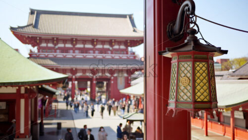 Close up of a hanging lantern with a blurred view of people walking at the Senso-ji temple in Tokyo, Asakusa, Japan - Starpik Stock