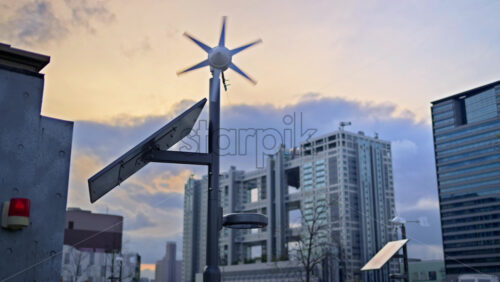 Close up of a small-scale renewable energy station with a wind turbine and a solar panel in Daiba, Tokyo, Japan - Starpik Stock