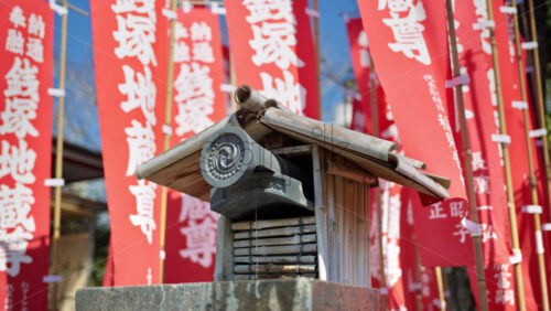 Close up of a small water fountain surrounded by red flags at the Senso-ji temple in Asakusa, Tokyo, Japan - Starpik Stock