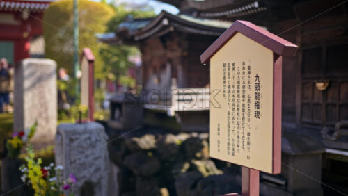 Close up of a wooden informational sign with a blurred background at the Senso-ji temple in Asakusa, Tokyo, Japan - Starpik Stock