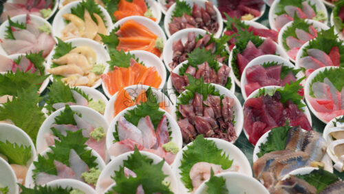 Close up of different seafood in small white bowls on display at the Tsukiji Fish Market in Japan - Starpik Stock