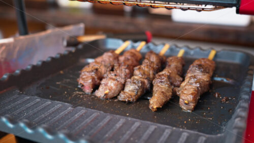 Close up of grilled meat on skewers at the Tsukiji Fish Market in Japan - Starpik Stock