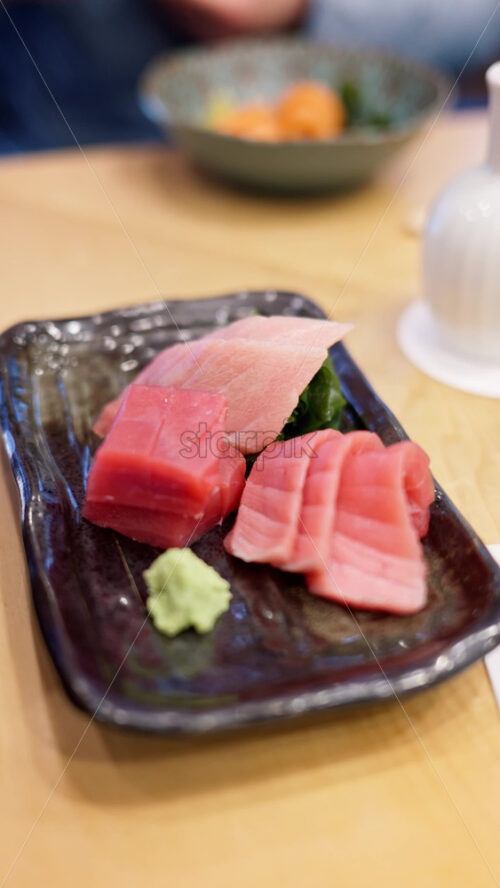 Close up of multiple pieces of tuna on display at the Tsukiji Fish Market in Japan. Vertical - Starpik Stock