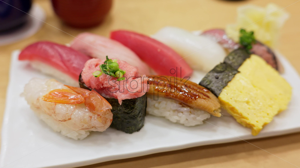 Close up of nigiri on a white plate at the Tsukiji Fish Market in Japan - Starpik Stock