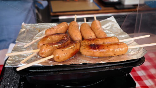 Close up of sausages on skewers flying at the Tsukiji Fish Market in Japan - Starpik Stock