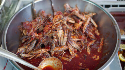 Close up of seafood in red sauce at the Tsukiji Fish Market in Japan - Starpik Stock