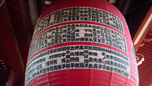 Close up of writing on a red hanging lantern at the Senso-ji temple in Asakusa, Tokyo, Japan - Starpik Stock