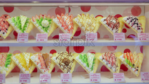 Crepes with whipped cream, different fruit and toppings on display on the Takeshita shopping street in Tokyo, Japan - Starpik Stock