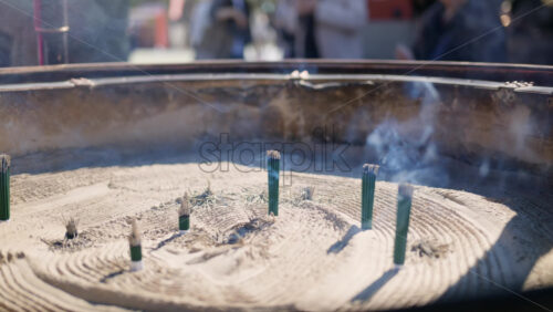 Incense burning on a jokoro at the Senso-ji temple in daylight in Tokyo, Japan - Starpik Stock