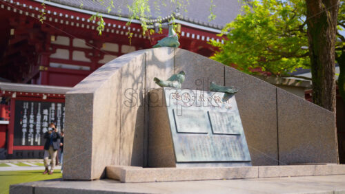 Stone sculpture at the Senso-ji temple in daylight in Tokyo, Japan - Starpik Stock