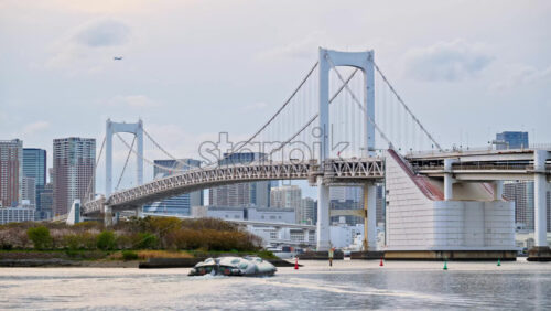 View of the Rainbow Bridge and the skyline of Tokyo, Japan on a cloudy day - Starpik Stock