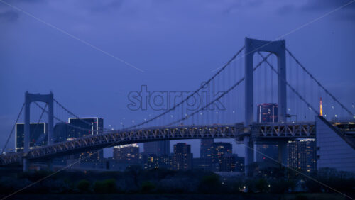View of the Rainbow Bridge and the skyline of the Tokyo, Japan in the evening - Starpik Stock