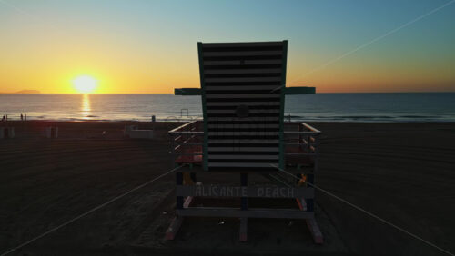 Aerial drone view of a colourful lifeguard tower on the San Juan Beach in Alicante, Spain at sunset - Starpik Stock