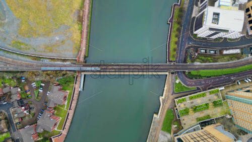 Aerial drone view of a train moving over the Belfast Railway Bridge above River Lagan in Belfast, Northern Ireland - Starpik Stock