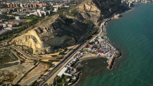 Aerial drone view of cars moving along the coastline in Alicante, Spain in daylight - Starpik Stock