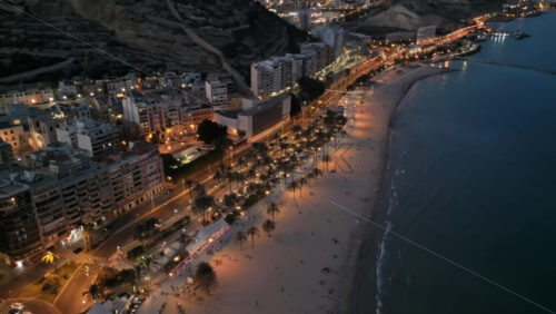Aerial drone view of cars moving along the coastline in Alicante, Spain in the evening - Starpik Stock