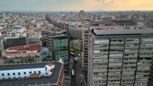 Aerial drone view of cars moving on the streets between the buildings, near Porta De La Mar in Valencia, Spain in daylight - Starpik Stock