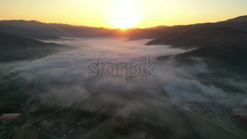 Aerial drone view of clouds above Castiglion Fiorentino in eastern Tuscany, Italy at sunrise - Starpik Stock