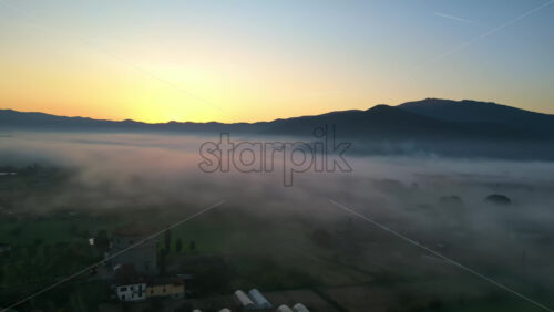 Aerial drone view of clouds above Castiglion Fiorentino in eastern Tuscany, Italy at sunrise - Starpik Stock