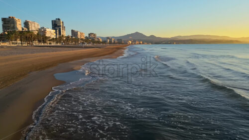 Aerial drone view of the Mediterranean Sea and the city of Alicante, Spain at sunset - Starpik Stock