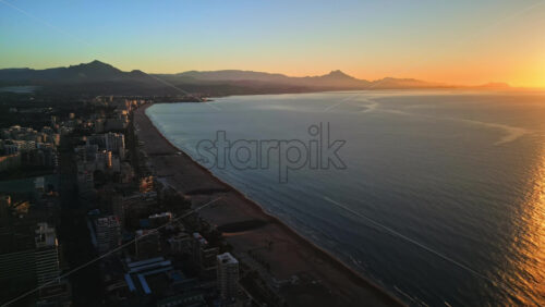 Aerial drone view of the Mediterranean Sea and the city of Alicante, Spain at sunset - Starpik Stock