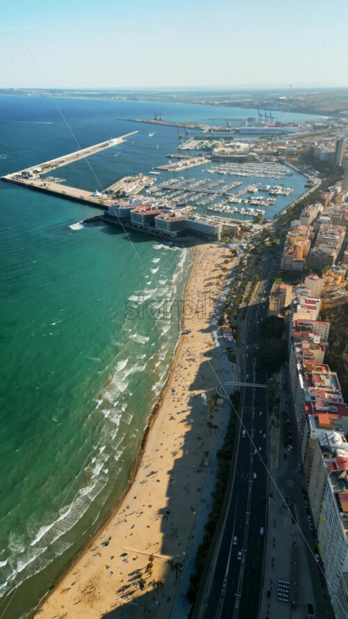 Aerial drone view of the Port of Alicante and the buildings in the city in daylight. Vertical - Starpik Stock