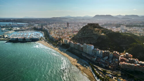 Aerial drone view of the Santa Barbara Castle on the coast of Alicante, Spain with the city and the sea in daylight - Starpik Stock