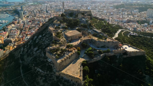 Aerial drone view of the Santa Barbara Castle on the coast of Alicante, Spain with the city and the sea on the background - Starpik Stock