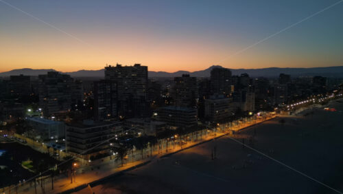 Aerial drone view of the beach and the Alicante city in Spain at sunset - Starpik Stock