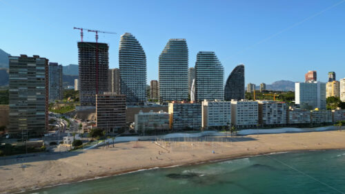 Aerial drone view of the buildings along the coastline and the sea in Benidorm, Spain in daylight - Starpik Stock