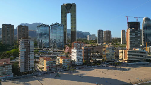 Aerial drone view of the buildings along the coastline and the sea in Benidorm, Spain in daylight - Starpik Stock