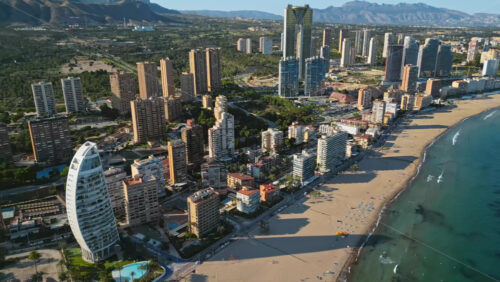 Aerial drone view of the buildings along the coastline and the sea in Benidorm, Spain in daylight - Starpik Stock