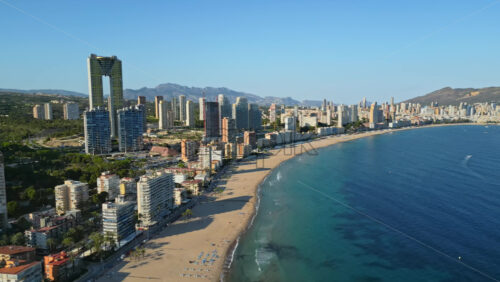 Aerial drone view of the buildings along the coastline and the sea in Benidorm, Spain in daylight - Starpik Stock