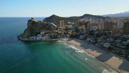 Aerial drone view of the buildings along the coastline and the sea in Benidorm, Spain in daylight - Starpik Stock