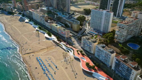 Aerial drone view of the buildings along the coastline and the sea in Benidorm, Spain in daylight - Starpik Stock