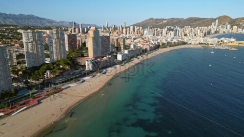 Aerial drone view of the buildings along the coastline and the sea in Benidorm, Spain in daylight - Starpik Stock
