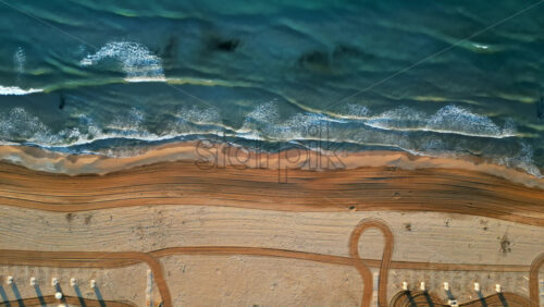 Aerial drone view of waves hitting the shore on the beach in Alicante, Spain - Starpik Stock