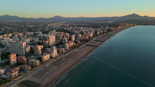 Aerial view of the beach and the buildings along the coastline in Alicante, Spain at sunset - Starpik Stock