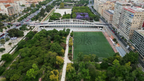 Cars and public transportation moving on the Exhibition Bridge near the Mestalla Stadium, and the Turia Gardens Park in Valencia, Spain - Starpik Stock